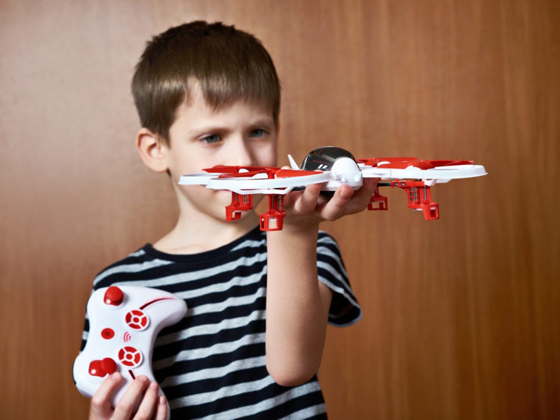 Little boy with toy quadcopter drone