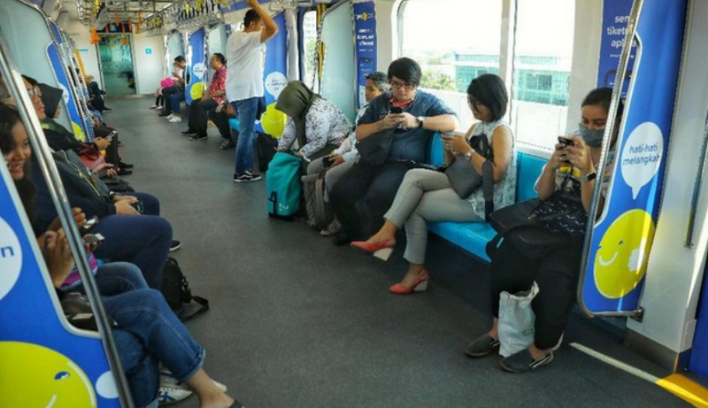 Penumpang MRT main ponsel