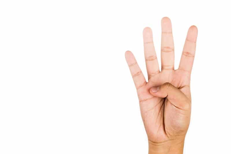 Hand gesturing number four against white background.