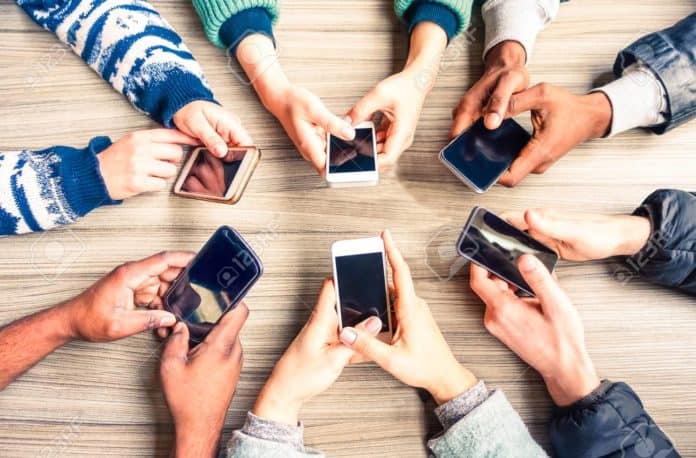 Hands circle using phones on table top view - Multiracial people Pengguna Smartphone Pinky Syndrome