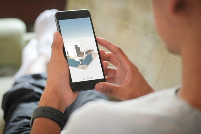 Midsection Of Man Using Mobile Phone At Home aplikasi desain rumah