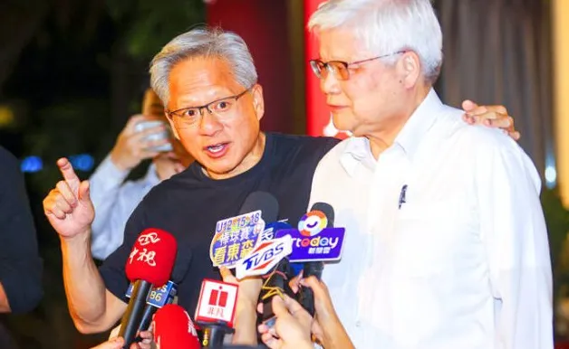 Dua pria dalam konferensi pers dikelilingi mikrofon, satu berbicara, yang lain mendengarkan dengan penuh perhatian.