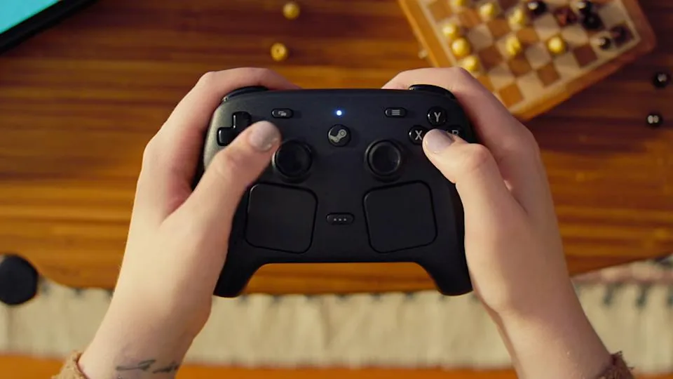 Seseorang memegang Steam Controller baru dengan trackpad terlihat jelas