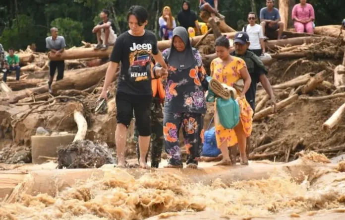 Warga melintasi jembatan darurat di Desa Garoga, Tapanuli Selatan, Sumatera Utara, pasca banjir dan tanah longsor.